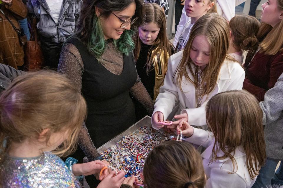 Girls pick out a complementary friendship bracelet before entering to see the Taylor Swift: The Eras Tour movie at the Lucas Theater on January 13, 2024, in Savannah, GA.