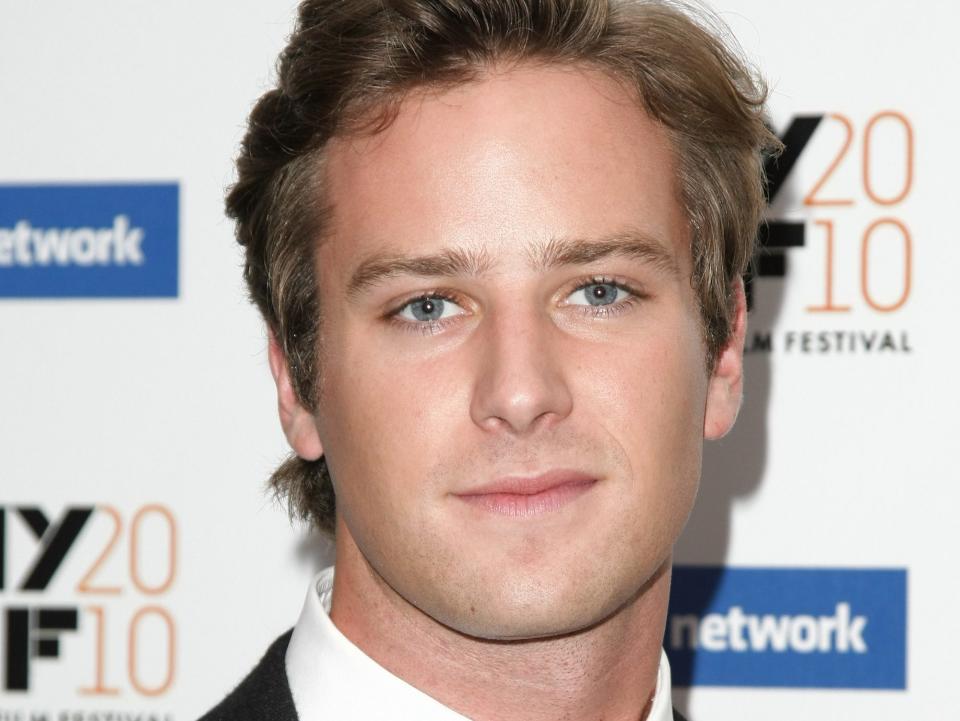 Armie Hammer, in a black suit and white shirt, poses during the New York Film Festival premiere of "The Social Network" in 2010.