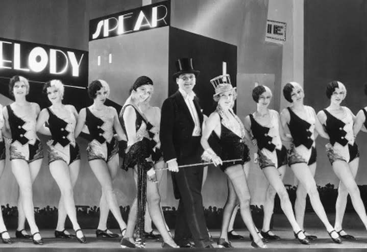 A chorus of dancers performs on a stage in The Broadway Melody.