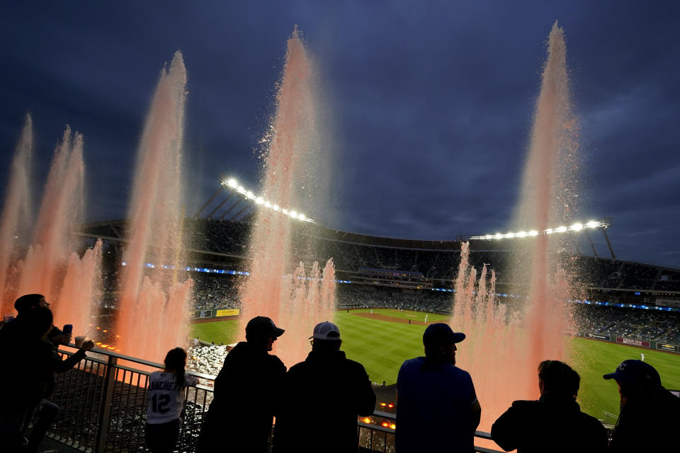 Fans watch from beyond the outfield fountains during the fifth inning of a baseball game between the Kansas City Royals and the Chicago White Sox on Friday, May 7, 2021, in Kansas City, Mo. (AP Photo/Charlie Riedel)