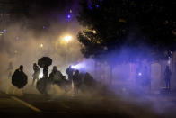 Tear gas fills the air during protests, Friday, Sept. 18, 2020, in Portland, Ore. The protests, which began over the killing of George Floyd, often result frequent clashes between protesters and law enforcement. (AP Photo/Paula Bronstein)