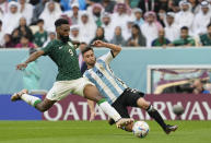 Saudi Arabia's Firas Al-Buraikan, left, fights for the ball with Argentina's Nicolas Tagliafico during the World Cup group C soccer match between Argentina and Saudi Arabia at the Lusail Stadium in Lusail, Qatar, Tuesday, Nov. 22, 2022. (AP Photo/Ebrahim Noroozi)