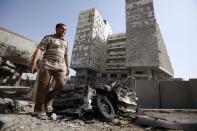 An Iraqi man walks past a destroyed vehicle after a car bomb explosion near the Finance Ministry in northern Baghdad, Iraq, Wednesday, Aug. 19, 2009. A series of deadly explosions targeting government and commercial buildings struck Baghdad Wednesday, killing scores of people and wounding many more Iraqi police and medical officials said. (AP Photo/Hadi Mizban)