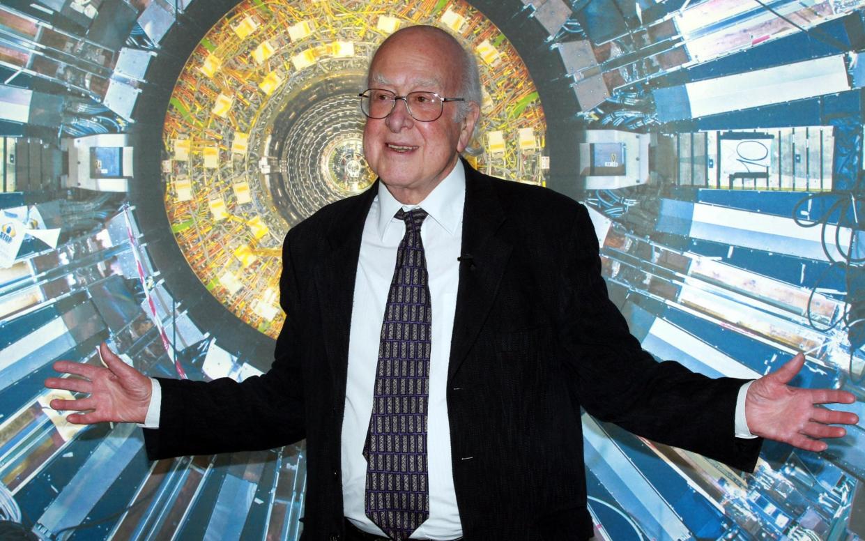 Higgs in 2013 in front of a photograph of the Large Hadron Collider at the Science Museum's 'Collider' exhibition in 2013