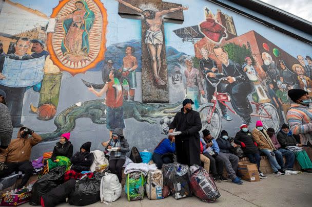PHOTO: Migrants eat and wait for help while camping on a street in downtown El Paso, Texas, Dec. 18, 2022. (Andres Leighton/AP)