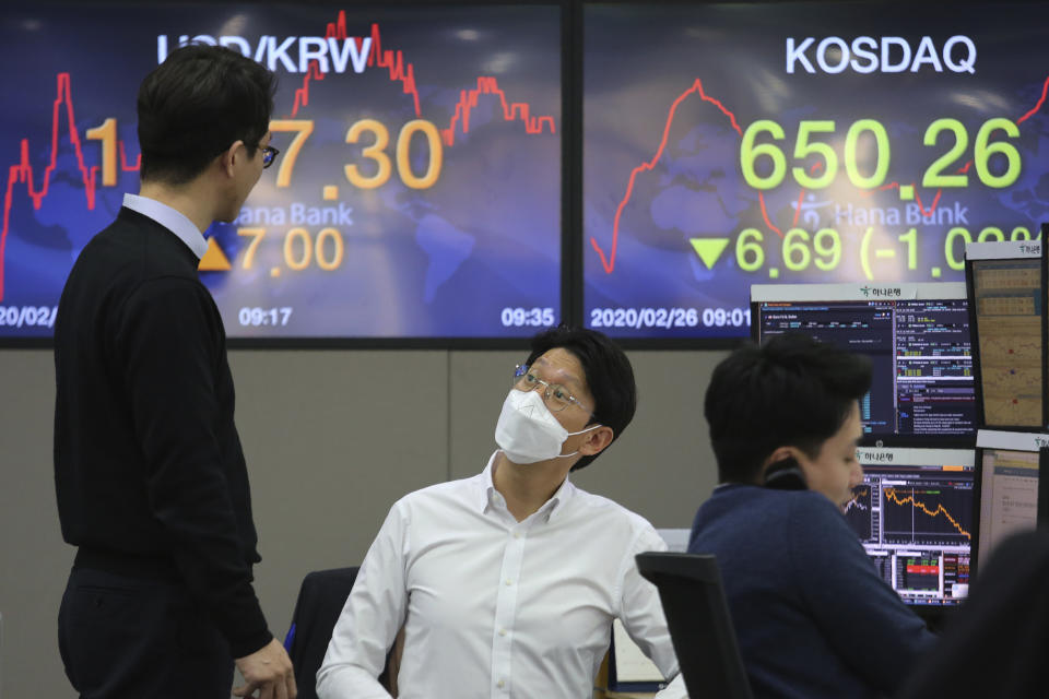 Currency traders work at the foreign exchange dealing room of the KEB Hana Bank headquarters in Seoul, South Korea, Wednesday, Feb. 26, 2020. Asian shares slid Wednesday following another sharp fall on Wall Street as fears spread that the growing virus outbreak will put the brakes on the global economy.(AP Photo/Ahn Young-joon)
