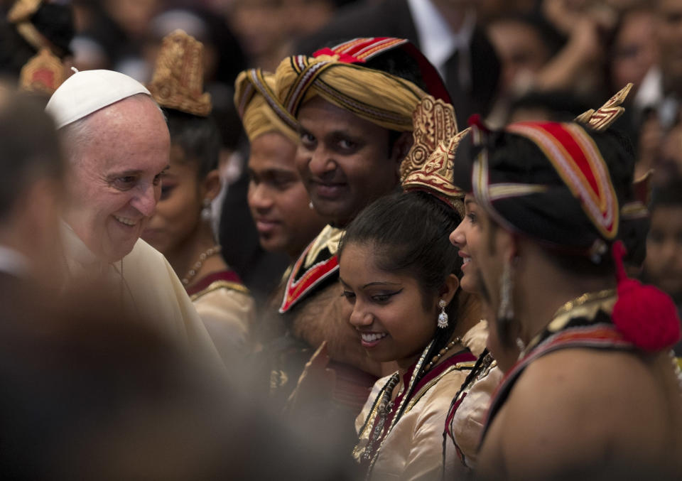 Pope Francis greets Sri Lankan dancers who performed during a mass for their community in St. Peter's Basilica at the Vatican, Saturday, Feb. 8, 2014. (AP Photo/Alessandra Tarantino)