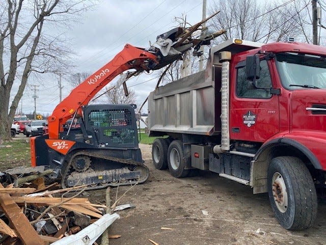 Storm debris is loaded by Muncie Sanitary District equipment into the back of a Delaware County Highway Department truck during the cleanup of a tornado that struck Selma the night of March 14.