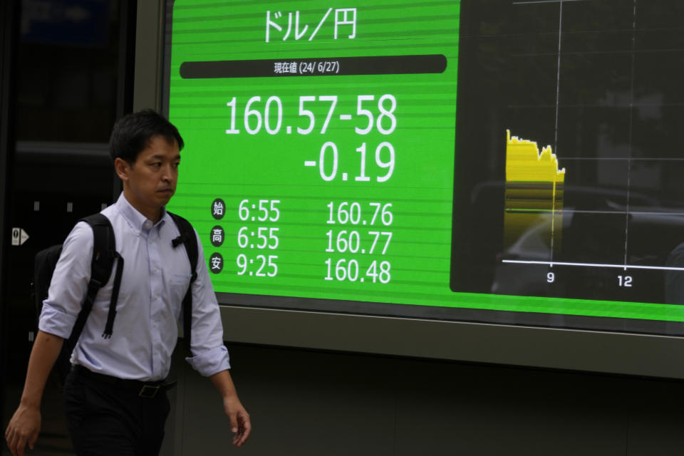 A person walks past an electronic stock board showing the exchange rate of U.S. dollar and Japanese yen at a securities firm Thursday, June 27, 2024 in Tokyo. (AP Photo/Shuji Kajiyama)
