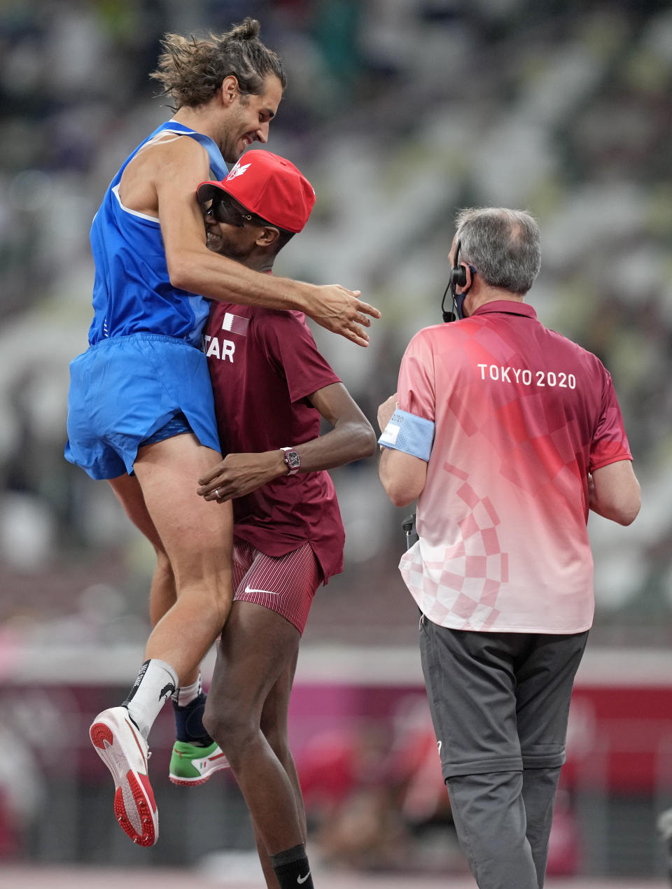 Gianmarco Tamberi, of Italy celebrates with Mutaz Barshim of Qatar after they won joint gold in the final of the men's high jump at the 2020 Summer Olympics, Sunday, Aug. 1, 2021, in Tokyo, Japan. (AP Photo/Martin Meissner)