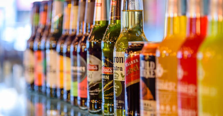 row of bottles and cans of alcoholic drinks on display