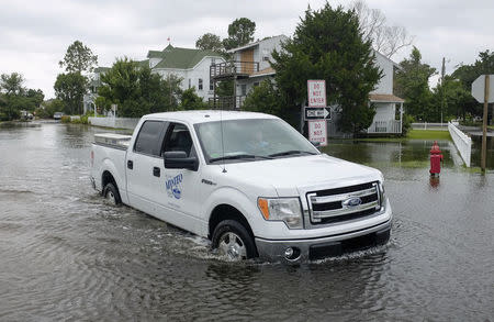 A city worker drives his truck through a flooded street after Hurricane Arthur passed through in Manteo, North Carolina July 4, 2014. REUTERS/Chris Keane