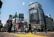 Less than usual pedestrians cross the Shibuya crossing after the government announced the state of emergency for the capital following the coronavirus disease outbreak in Tokyo, Japan