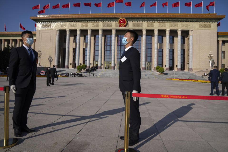 Security personnel stand outside the Great Hall of the People before the opening ceremony of the 20th National Congress of China's ruling Communist Party in Beijing, Sunday, Oct. 16, 2022. The overarching theme emerging from China's ongoing Communist Party congress is one of continuity, not change. The weeklong meeting is expected to reappoint Xi Jinping as leader, reaffirm a commitment to his policies for the next five years and possibly elevate his status even further as one of the most powerful leaders in China's modern history. (AP Photo/Mark Schiefelbein)