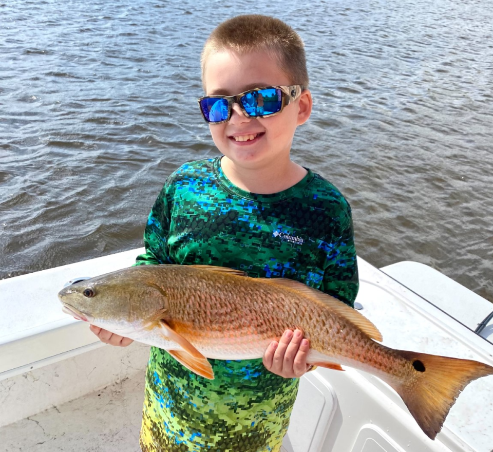 Eight-year-old Kyle Oglesby, of Edgewater, with a 26-inch redfish he caught from Capt. Jeff Patterson's "Pole Dancer" charter boat. "He managed to get it away from the mangroves all on his own," Patterson says.