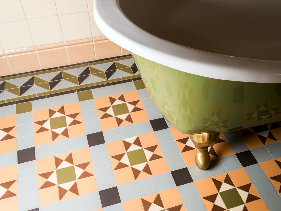 green bathtub on top of colored bathroom tiles