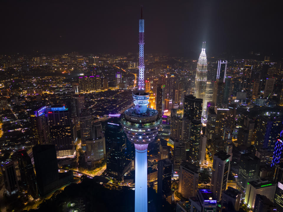 Aerial view of illuminated KL tower and skyscrapers in Kuala Lumpur city at dusk