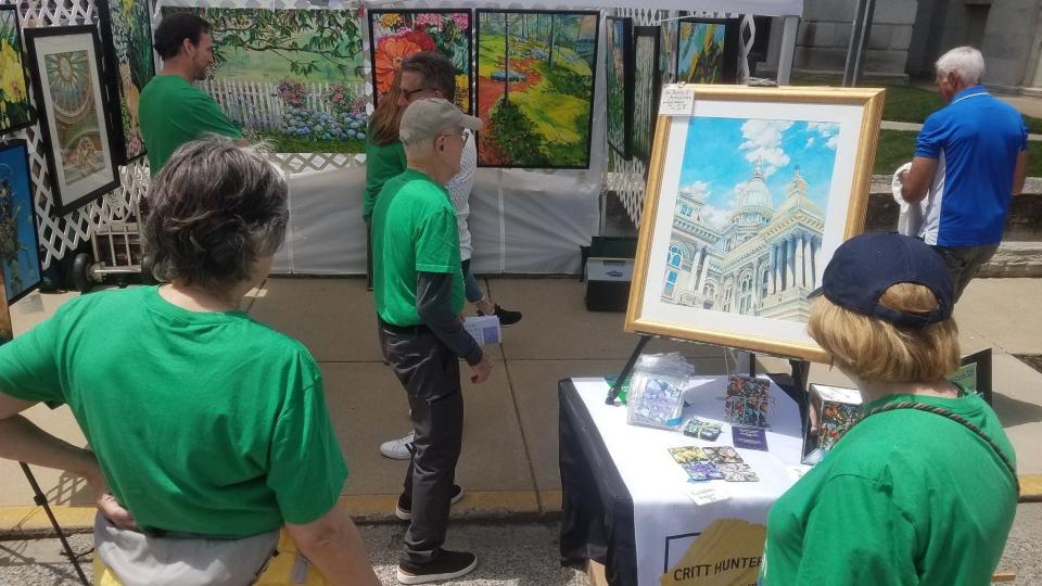 An exhibitor displays artwork during the 2022 Round the Fountain Art Fair, held in the streets near the Tippecanoe County Courthouse the last Saturday in May. This year's event will be held from 9 a.m. to 4:30 p.m. Saturday, May 25.