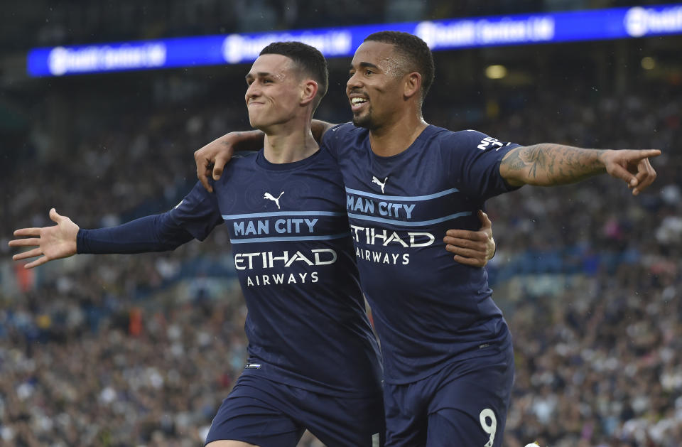 Manchester City's Gabriel Jesus, right, celebrates with Manchester City's Phil Foden after scoring his side's third goal during the English Premier League soccer match between Leeds United and Manchester City at Elland Road in Leeds, England, Saturday, April 30, 2022. (AP Photo/Rui Vieira)