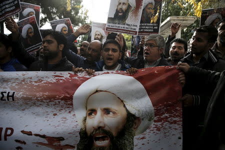 Shi'ite Muslims living in Greece hold pictures of Shi'ite cleric Sheikh Nimr al-Nimr and shout slogans during a demonstration against his execution in Saudi Arabia, outside the embassy of Saudi Arabia in Athens, Greece, January 6, 2016. REUTERS/Alkis Konstantinidis