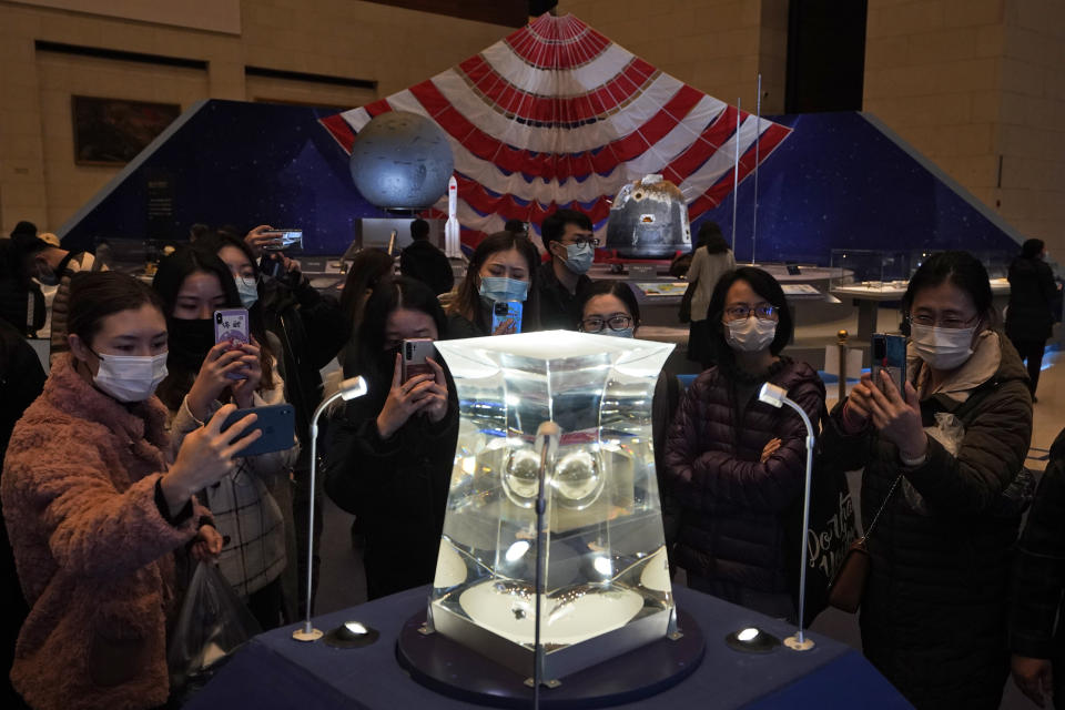 FILE - In this March 12, 2021, file photo, visitors to the National Museum look at a display of the lunar rock samples retrieved from the moon by China's Chang'e 5 lunar lander late last year in Beijing. Moon rocks that a Chinese robotic space craft brought back to Earth last year have provided new insights into ancient lunar volcanic activity, a researcher said Tuesday, Oct. 19. (AP Photo/Ng Han Guan, File)