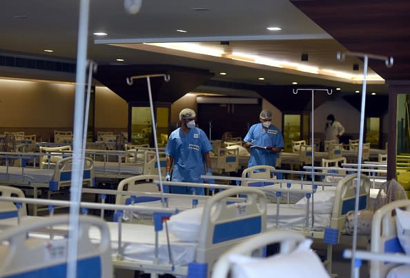 Medical professionals inspect beds set up inside Shehnai Banquet Hall temporarily converted to an emergency Covid care centre under the LNJP Hospital in New Delhi, India.