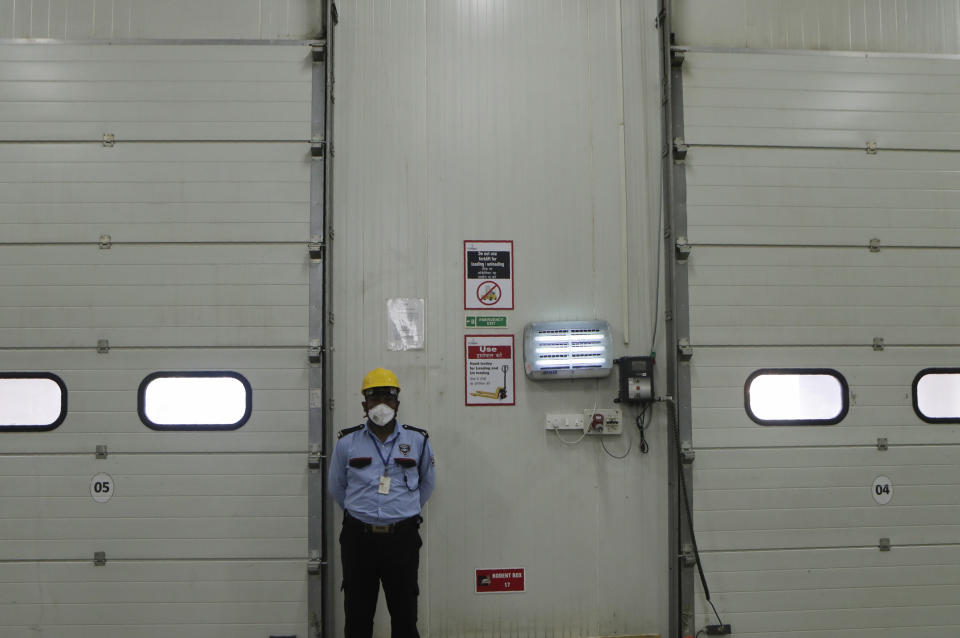 A security guard stands by at Snowman Logistics, India's largest cold storage company in Taloja on the outskirts of Mumbai, India, Saturday, Oct. 17, 2020. The vaccine cold chain hurdle is just the latest disparity of the pandemic weighted against the poor, who more often live and work in crowded conditions that allow the virus to spread, have little access to medical oxygen vital to COVID-19 treatment, and whose health systems lack labs, supplies or technicians to carry out large-scale testing. (AP Photo/Rajanish Kakade)