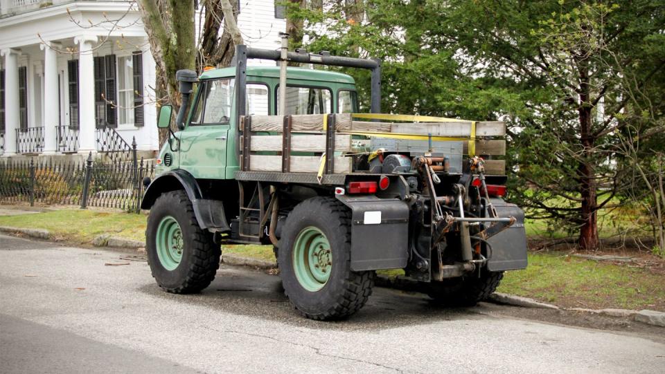 a green truck parked on the side of a road