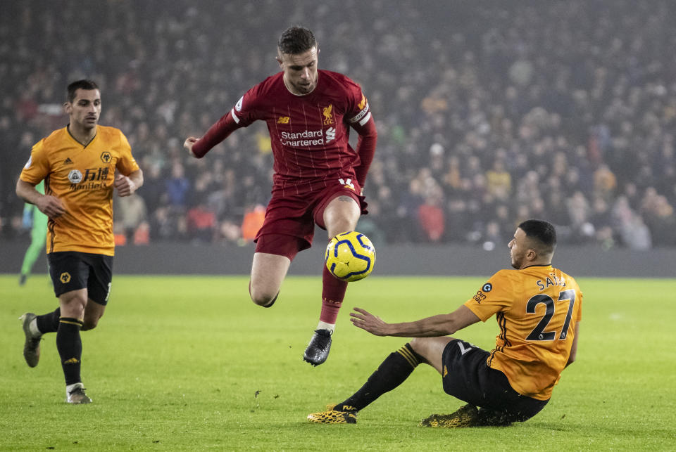 Liverpool's Jordan Henderson (centre) competing with Wolverhampton Wanderers' Romain Saiss during their Premier League match.