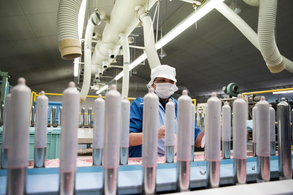 An employee of Japanese condom maker Sagami Rubber Industries performs quality tests for randomly picked condoms at the company's testing facility in Atsugi, Kanagawa prefecture ahead of the Olympic Games.