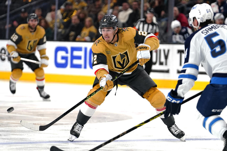 Vegas Golden Knights defenseman Zach Whitecloud (2) passes the puck as Winnipeg Jets' Dylan Samberg (54) defends during the second period of Game 2 of an NHL hockey Stanley Cup first-round playoff series Thursday, April 20, 2023, in Las Vegas. (AP Photo/Lucas Peltier)