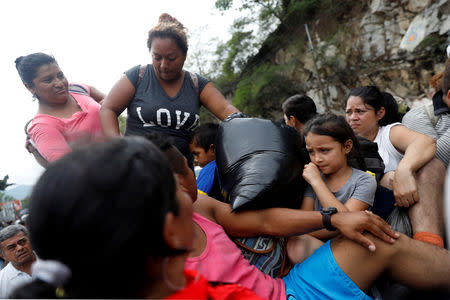 Honduran migrants, part of a caravan trying to reach the U.S., are pictured on a truck during a new leg of their travel in Zacapa, Guatemala October 17, 2018. REUTERS/Edgard Garrido