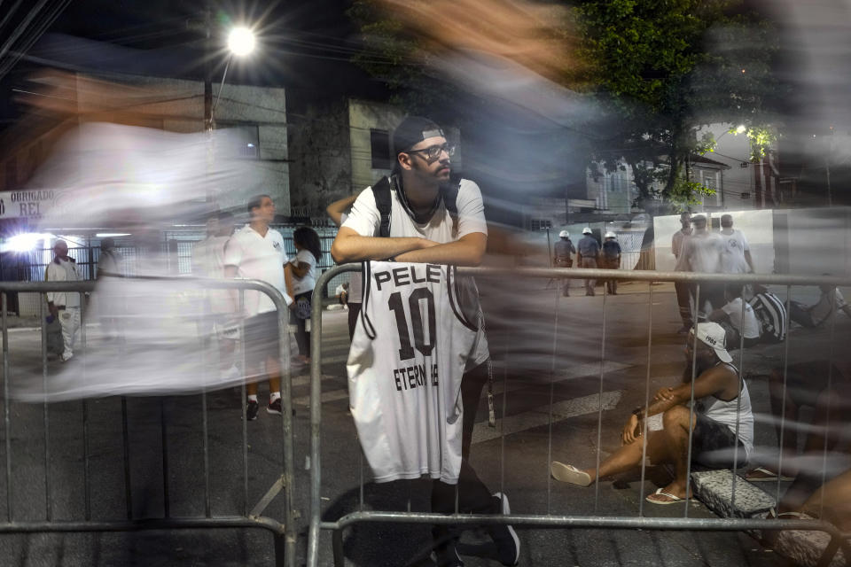A soccer fans rests after paying his last respects to the late Brazilian soccer great Pele who lies in state at Vila Belmiro stadium in Santos, Brazil, early Tuesday, Jan. 3, 2023. (AP Photo/Matias Delacroix)