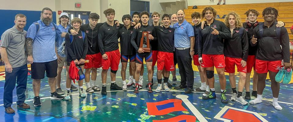 Members of the Manatee High wrestling team pose with the Class 2A-District 10 trophy after winning four bouts Friday at Manatee High.