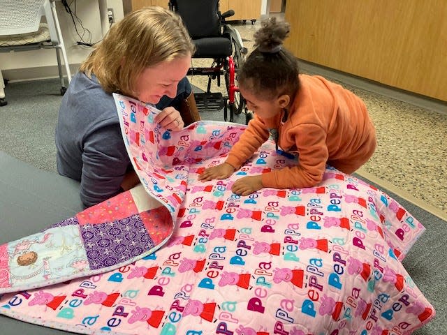Island Hines and GRCC instructor Julie Sizemore look at the quilt made for Island by Love Sews Ministry in Holland.