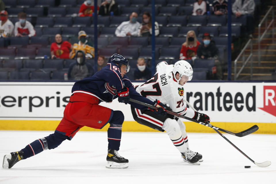 Chicago Blackhawks' Kirby Dach, right, looks for an open shot as Columbus Blue Jackets' Gabriel Carlsson defends during the first period of an NHL hockey game Saturday, April 10, 2021, in Columbus, Ohio. (AP Photo/Jay LaPrete)