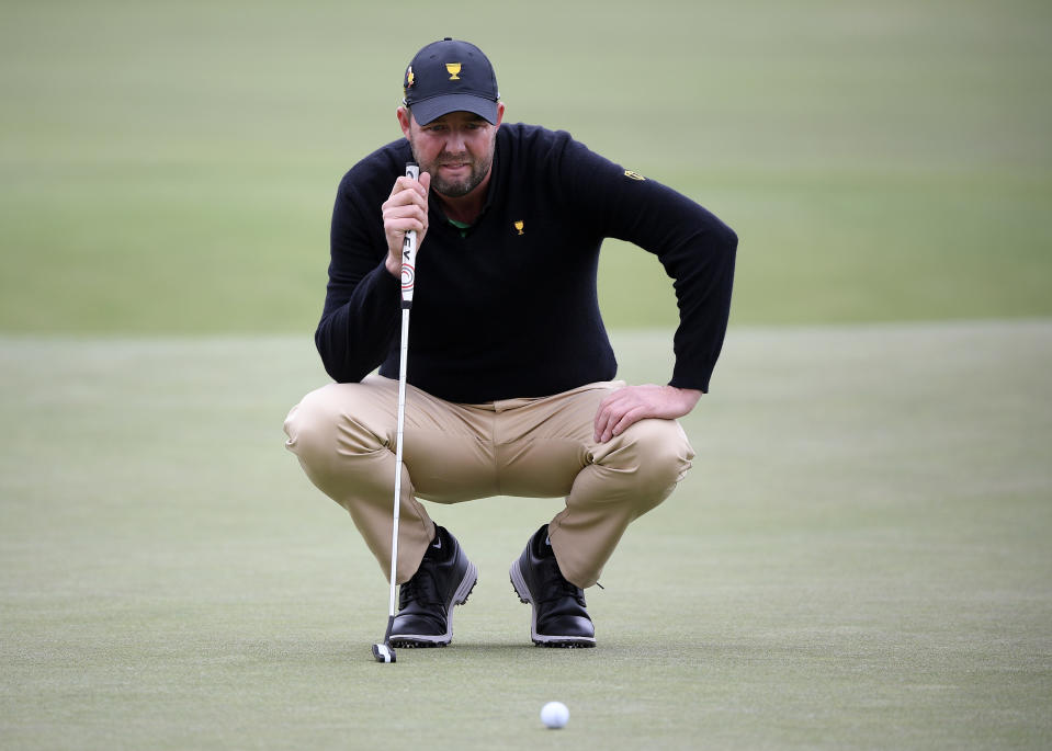 International team player Marc Leishman of Australia lines up his putt on the 2nd green during their fourball match at the Royal Melbourne Golf Club in the opening rounds of the President's Cup golf tournament in Melbourne, Thursday, Dec. 12, 2019. (AP Photo/Andy Brownbill)