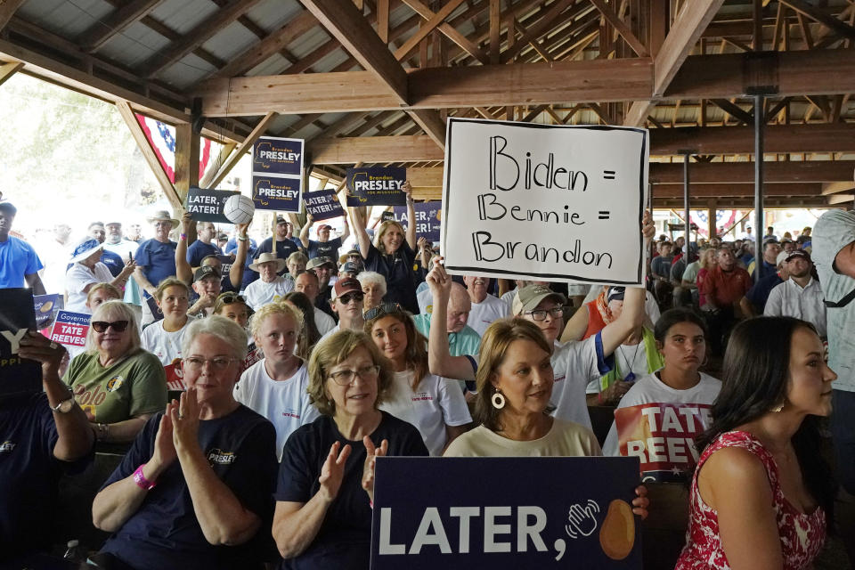 A person holds a sign that links President Joe Biden to Democratic U.S. Rep. Bennie Thompson of Mississippi and Brandon Presley, the Democratic nominee for Mississippi governor at the Neshoba County Fair near Philadelphia, Miss., on July 27, 2023. As Republican Gov. Tate Reeves seeks a second term, he faces Presley and independent candidate Gwendolyn Gray in the Nov. 7, 2023, general election. Reeves often says a vote for Presley equates to a vote for Biden and Thompson. (AP Photo/Rogelio V. Solis)