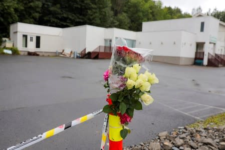 Flowers and a police tape are seem outside Al-Noor Islamic Centre Mosque, a day after a gunman's attack, in Baerum outside Oslo