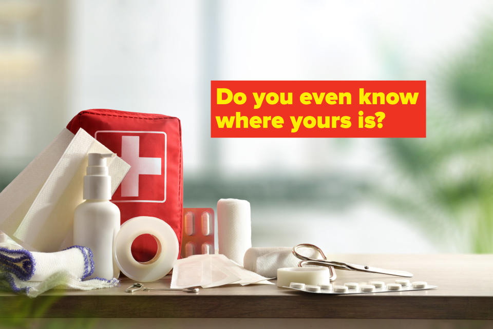 First aid supplies including medical tape, packaged pills, scissors, and bandages displayed in front of a first aid kit