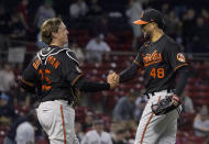 Baltimore Orioles catcher Adley Rutschman, left, congratulates relief pitcher Jorge Lopez (48) after the team's win over the Boston Red Sox in a baseball game at Fenway Park, Friday, May 27, 2022, in Boston. (AP Photo/Mary Schwalm)