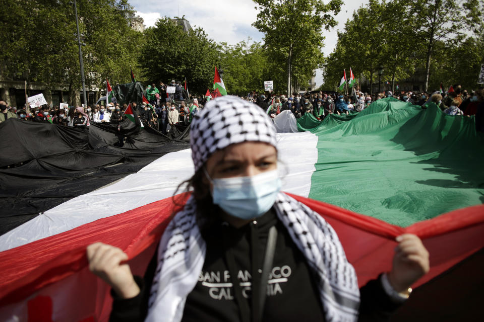 Protesters hold a giant Palestinian flag in Paris, Saturday, May 22, 2021, as they take part in a rally supporting Palestinians. Egyptian mediators held talks Saturday to firm up an Israel-Hamas cease-fire as Palestinians in the Hamas-ruled Gaza Strip began to assess the damage from 11 days of intense Israeli bombardment.Supporters of the Palestinians. (AP Photo/Thibault Camus)