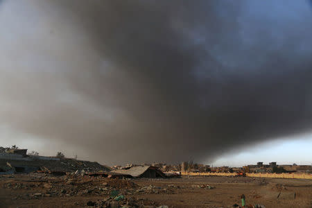 Smoke rises from oil wells set ablaze by Islamic State militants before fleeing the oil-producing region of Qayyara, Iraq, January 11, 2017. Picture taken January 11, 2017. REUTERS/Girish Gupta
