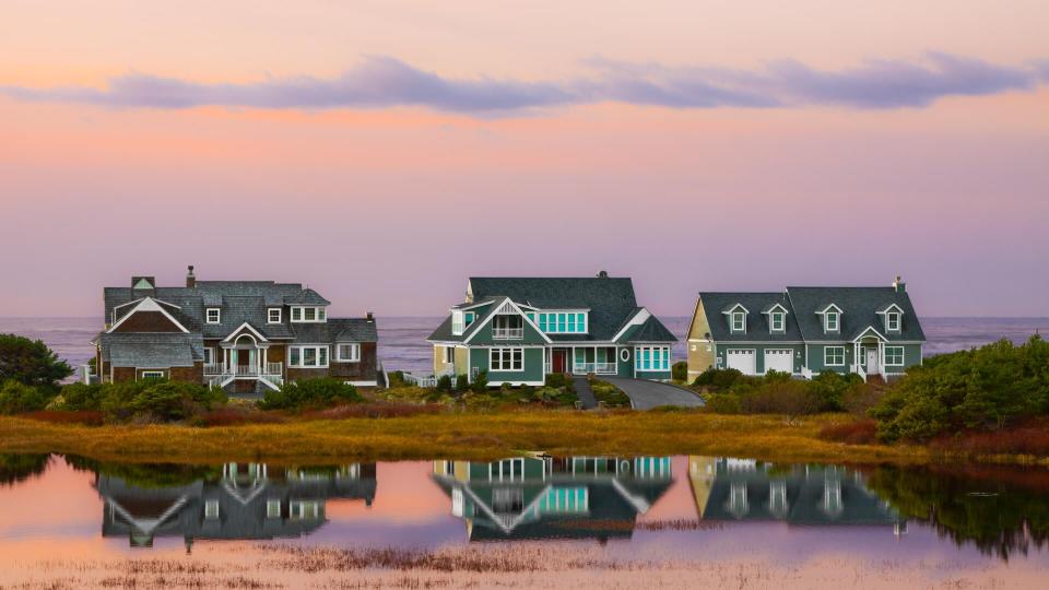 It is a beautiful scene with the sunset, but the large beach houses are located on a low land that could be in jeopardy if there is a tsunami wave.