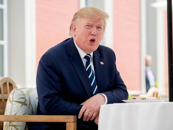 Donald Trump talks to the media as he sits for lunch with French president Emmanuel Macron. (AP)