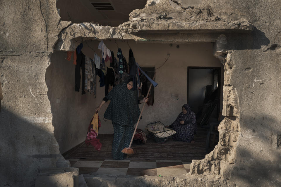 A resident of Al-Baali Street cleans a room inside her home, heavily damaged by airstrikes in Beit Hanoun, northern Gaza Strip, Friday, June 18, 2021. (AP Photo/Felipe Dana)