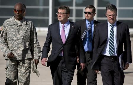 U.S. Defense Secretary Ash Carter, accompanied by his Chief of Staff Eric Rosenbach (R) and U.S. Army Lt. Gen. Ron Lewis (L) walks on the tarmac before boarding his plane at Queen Alia Airport in Amman, Jordan, July 24, 2015. REUTERS/Carolyn Kaster/Pool
