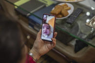 Afifa, 61, video calls with their grandson on the first day of Eid in lockdown due to the Coronavirus pandemic, in Casablanca, Morocco, Sunday, May 24, 2020. Instead of mass prayers and large family gatherings filled with colorful clothes, gifts, and traditional foods, millions of Moroccan Muslims celebrated Eid Al-Fitr at home, subdued and isolated amid their country's newly extended coronavirus lockdown. (AP Photo/Mosa'ab Elshamy)