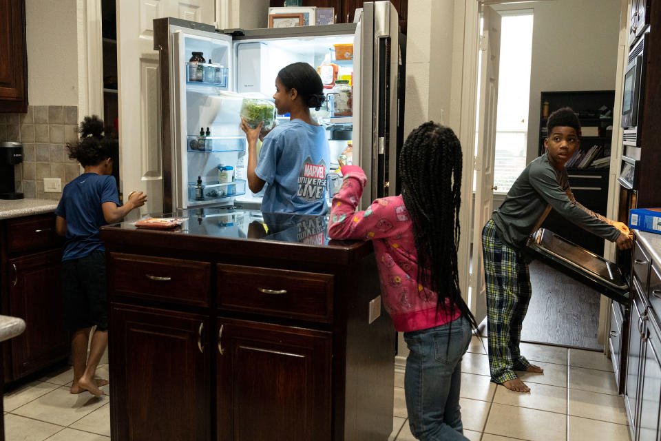 Four of the Thomas siblings make lunch after school lessons in the family's kitchen.<span class="copyright">Ilana Panich-Linsman for TIME</span>