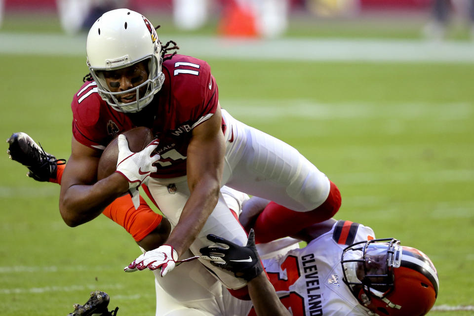 Arizona Cardinals wide receiver Larry Fitzgerald (11) is hit by Cleveland Browns defensive back T.J. Carrie during the first half of an NFL football game, Sunday, Dec. 15, 2019, in Glendale, Ariz. (AP Photo/Ross D. Franklin)